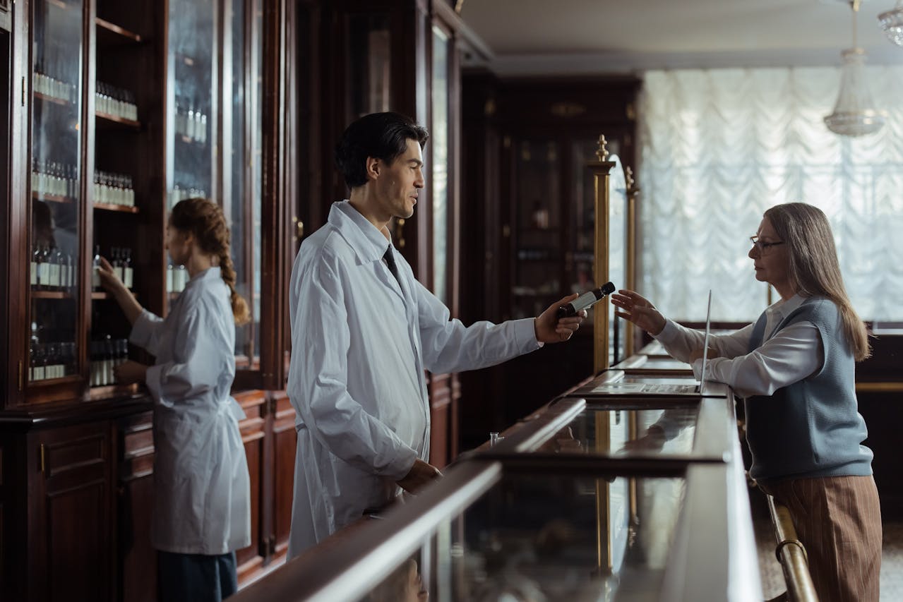 Man giving a bottle of medicine to a patient.